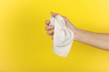 Sarı arka planda beyaz bir bez ya da bez mendil tutuyordu.