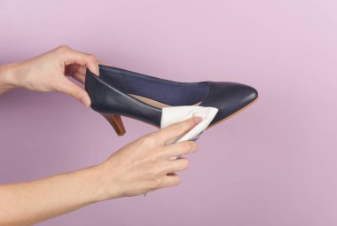 Deri ayakkabıları paçavrayla temizleyen kadın elleri.