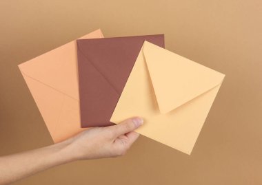 Bej arkaplanda el ele tutuşma zarfları