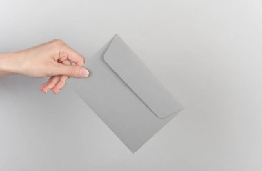 Gri arkaplanda el ele tutuşan zarf