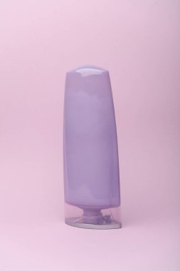 Mor pastel arka planda şampuan şişesi