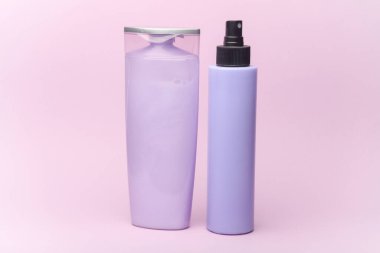 Mor pastel arka planda şampuan ve sprey şişeleri