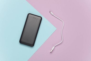 Mor mavi pastel arka planda kablolu güç bankası