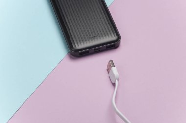 Mor mavi pastel arka planda kablolu güç bankası