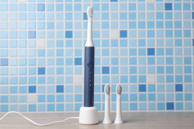 Masada kafaları olan modern, ultrasonik diş fırçası var.