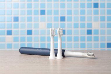 Masada kafaları olan modern, ultrasonik diş fırçası.