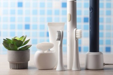 Masasında diş ipi, kafa ve diş macunu olan modern, ultrasonik diş fırçası.