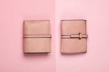 Pembe arka planda iki pembe deri cüzdan.