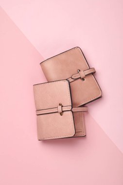 Pembe arka planda iki pembe deri cüzdan.