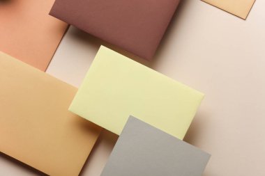 Bej arka planda gölgesi olan bir grup renkli boş kart kağıdı. Minimalizm marka şablonu, yaratıcı düzen