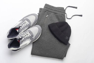 Beyaz arka planda eşofman, spor ayakkabı ve şapka. Üst Manzara. Spor kıyafetleri.