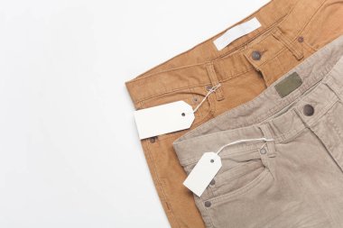 Beyaz arka planda etiketli kadife pantolon.