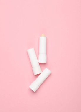 Pembe arka planda hijyenik dudak kremi tüpleri