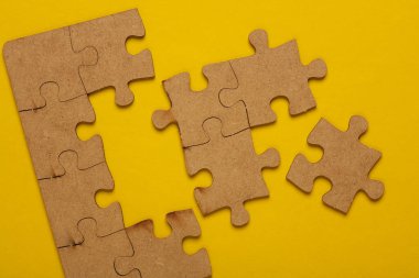 Tahta parçaları sarı arka planda yapboz