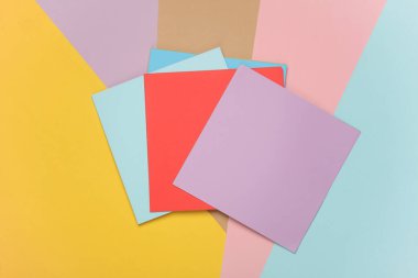 Renkli bir arkaplanda origami yaratıcılığı için kare kağıtlar