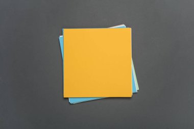 Koyu gri arka planda origami yaratıcılığı için kare renkli kağıtlar