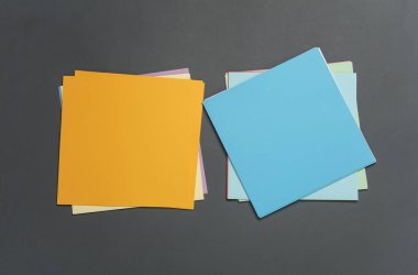 Koyu gri arka planda origami yaratıcılığı için kare renkli kağıtlar