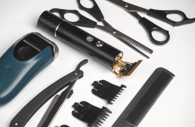 Makas, saç kesme makası ve jilet, beyaz arka planda tarak. Berberin çalışma aletleri. Yaratıcı düzen. Düz yatıyordu