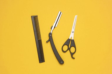 Sarı arka planda çalışan berber. Yerleşim planı. Düz yatıyordu. Üst görünüm