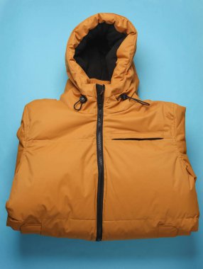 Mavi kapüşonlu sarı kış ceketi.