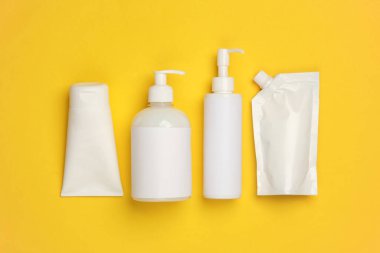 Sarı arka planda kozmetik şişeleri