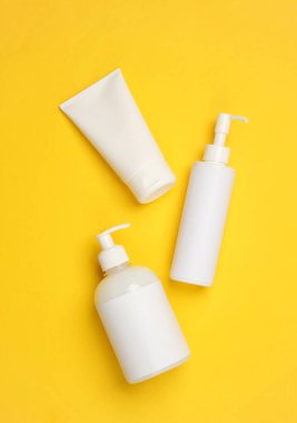 Sarı arka planda kozmetik şişeleri