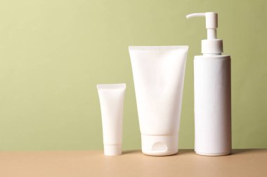 Yeşil bej arka planda kozmetik şişeleri