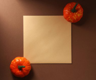 Kahverengi arkaplanda Cadılar Bayramı dekoru olan kare davetiye kartı