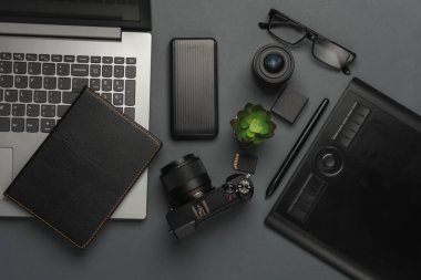 Siyah arka planda kamera ve fotoğraf aksesuarları olan bir laptop. Üst görünüm