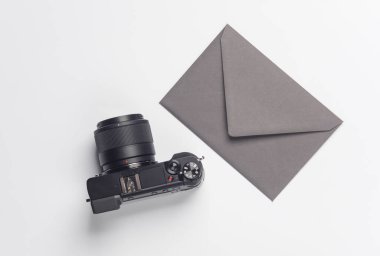 Beyaz arkaplanda modern kamera ve zarf