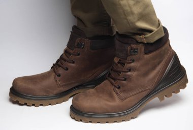 Beyaz arka planda sıcak kış botları giymiş erkek bacakları. Ordu tarzı.