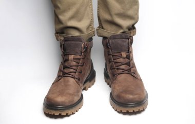 Beyaz arka planda sıcak kış botları giymiş erkek bacakları. Ordu tarzı.