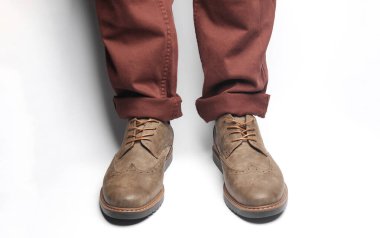 Beyaz arka planda siyah çizmeli erkek bacakları.