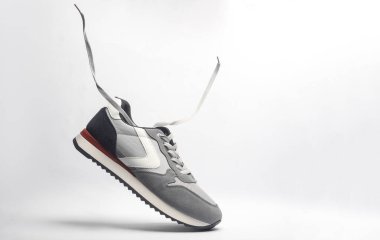 Beyaz arka planda uçan bağcıklı spor ayakkabıları.