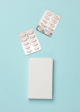 Mavi arka planda bir kutu hap