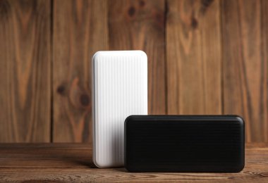 Tahta zemin üzerinde beyaz ve siyah batarya güç bankaları