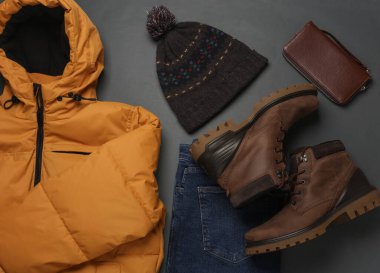 Koyu gri arka planda erkek kış kıyafetleri. Üst görünüm