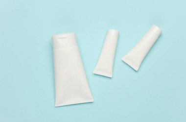 Mavi arka planda beyaz krem tüpleri. Kozmetik