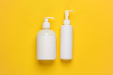 Sarı arkaplanlı krema şişeleri.