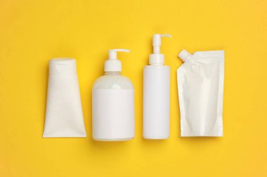 Sarı arka planda kozmetik şişeleri