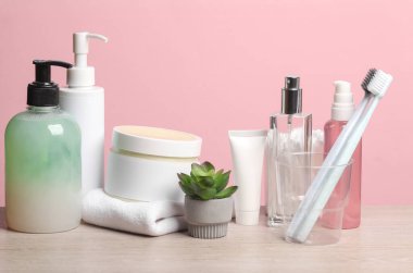 Kozmetik ürünler ve pembe arka planda çalar saat. Kişisel hijyen. Güzellik konsepti