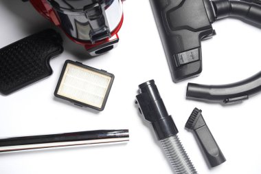 Beyaz arka planda modern bir elektrik süpürgesinin bileşenleri ve eklentileri. Üst Manzara. Boşluğu kopyala