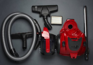 Karanlık arka planda modern bir elektrik süpürgesinin bileşenleri ve ekleri. Üst Manzara. Düz yatıyordu