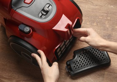 Eller elektrik süpürgesine toz filtresi yerleştiriyor.
