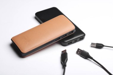 Beyaz arka planda birçok kablosu olan iki dış güç bankası bataryası.