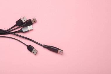 Pembe arka planda bir sürü USB kablosu