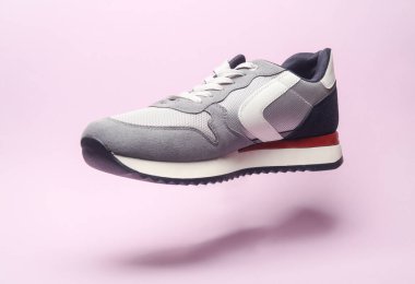 Pembe arka planda yüzen spor ayakkabısı