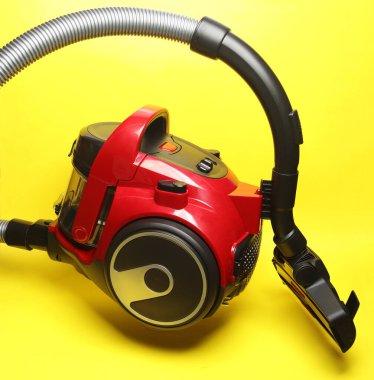 Sarı arka planda yüzen modern elektrik süpürgesi