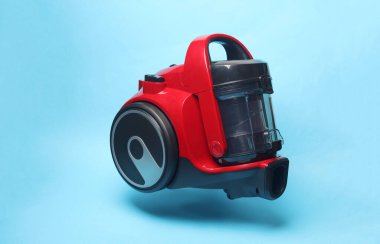 Mavi arka planda yüzen modern elektrik süpürgesi