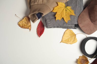 Erkek kıyafetleri, ayakkabılar ve aksesuarlar sonbahar yapraklı beyaz bir arka planda. Mevsimlik kıyafetler. Üst Manzara. Düz yatıyordu. Boşluğu kopyala